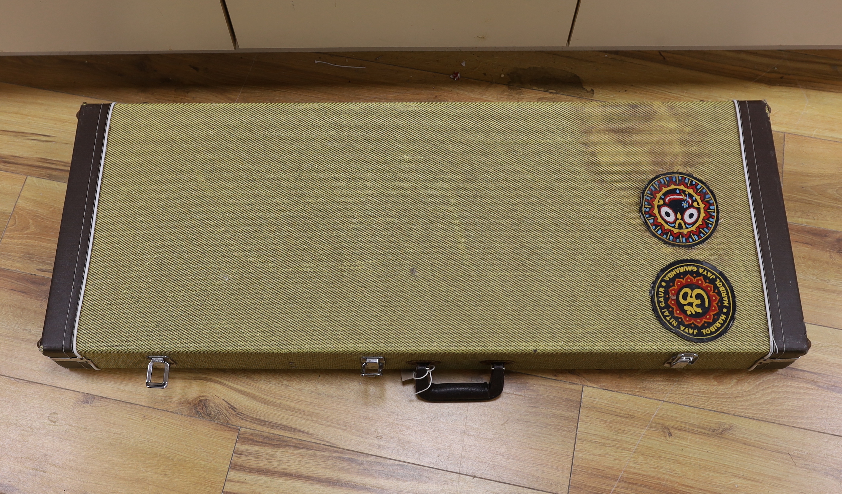 A cased Squier Strat by Fender electric guitar with rosewood neck and balance lacquer body, together with a Harris Tweed flight case